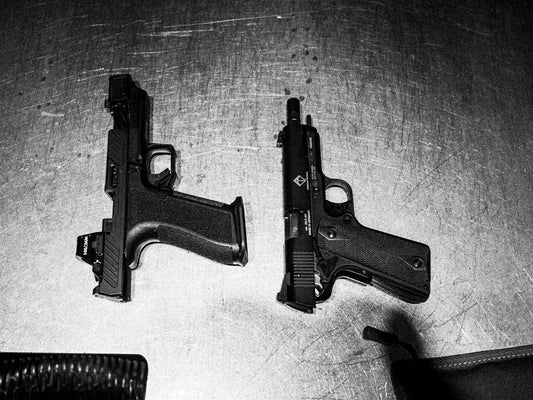 Two handguns are shown on a surface
